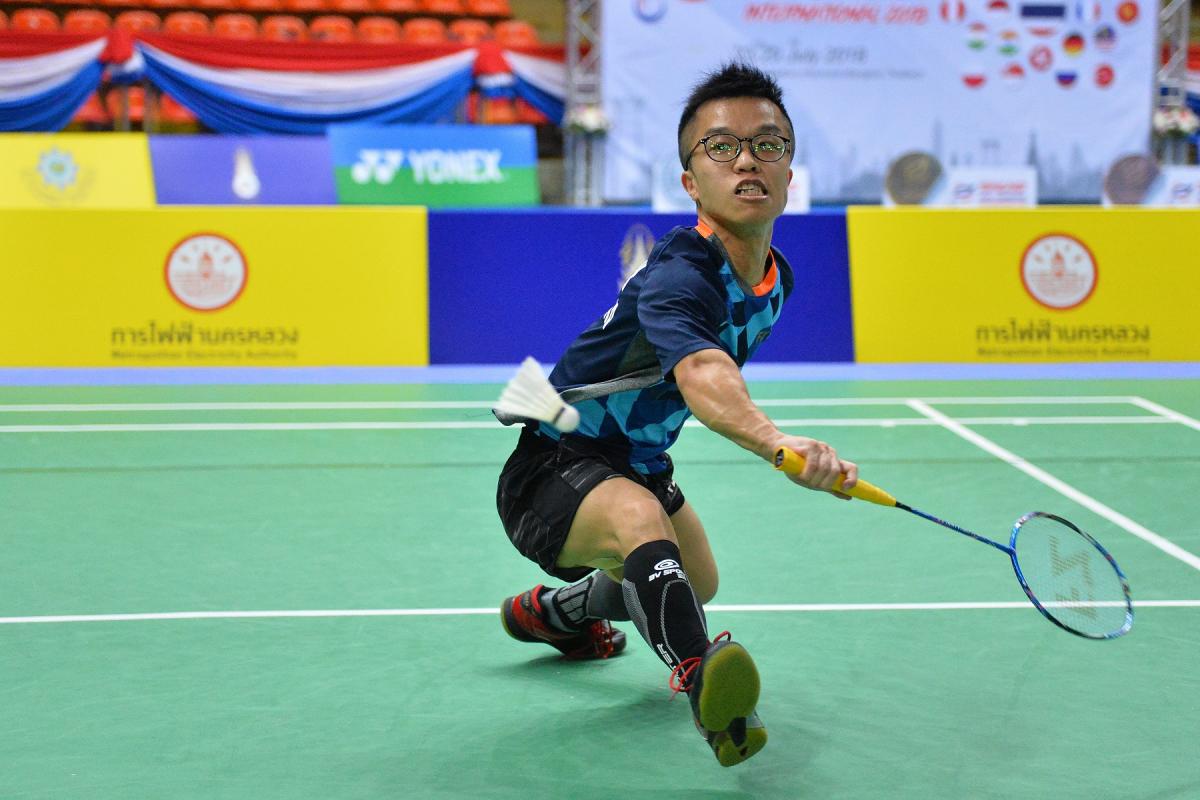 male Para badminton player Wong Chun Yim goes to hit a backhand