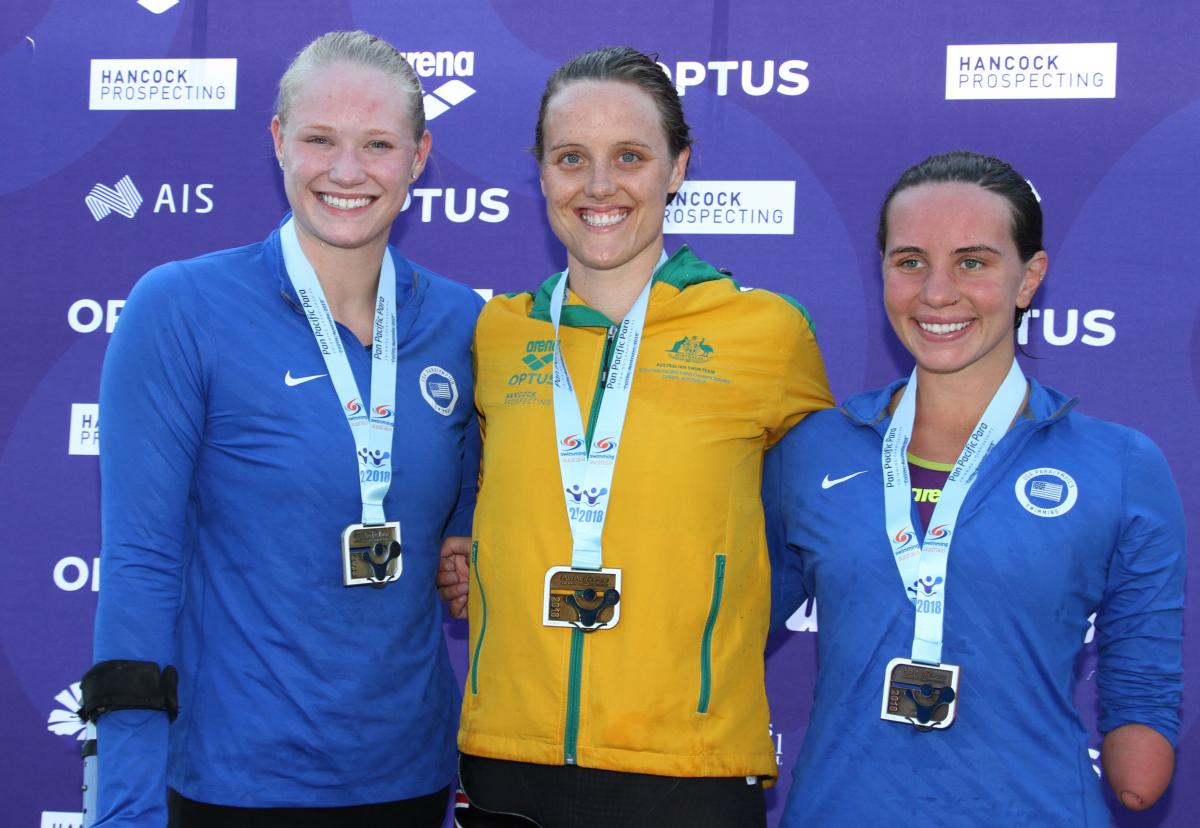 Three women with medals smiling