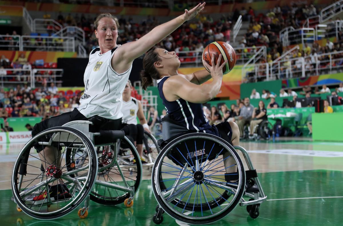 female wheelchair basketballer Marina Mohnen reaches over another player to block the ball