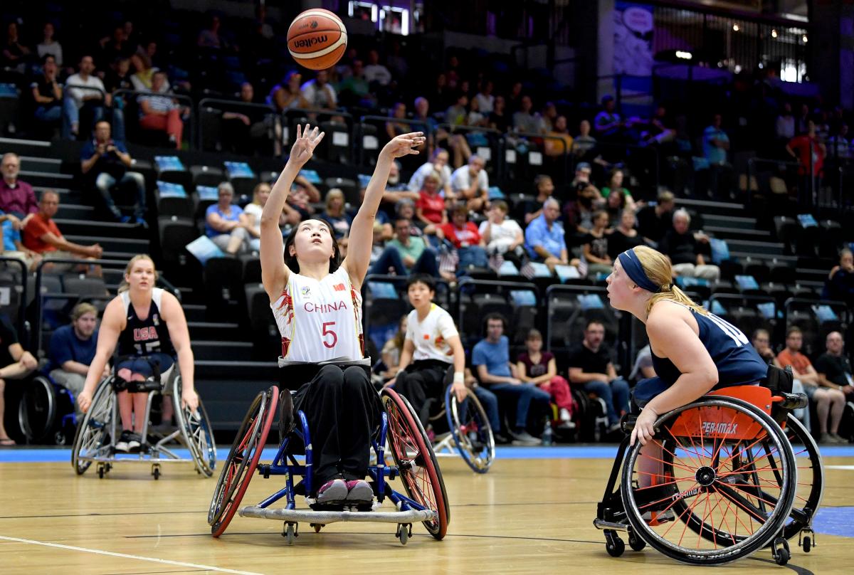 female wheelchair basketballer Xuemei Zhang challenges for the ball