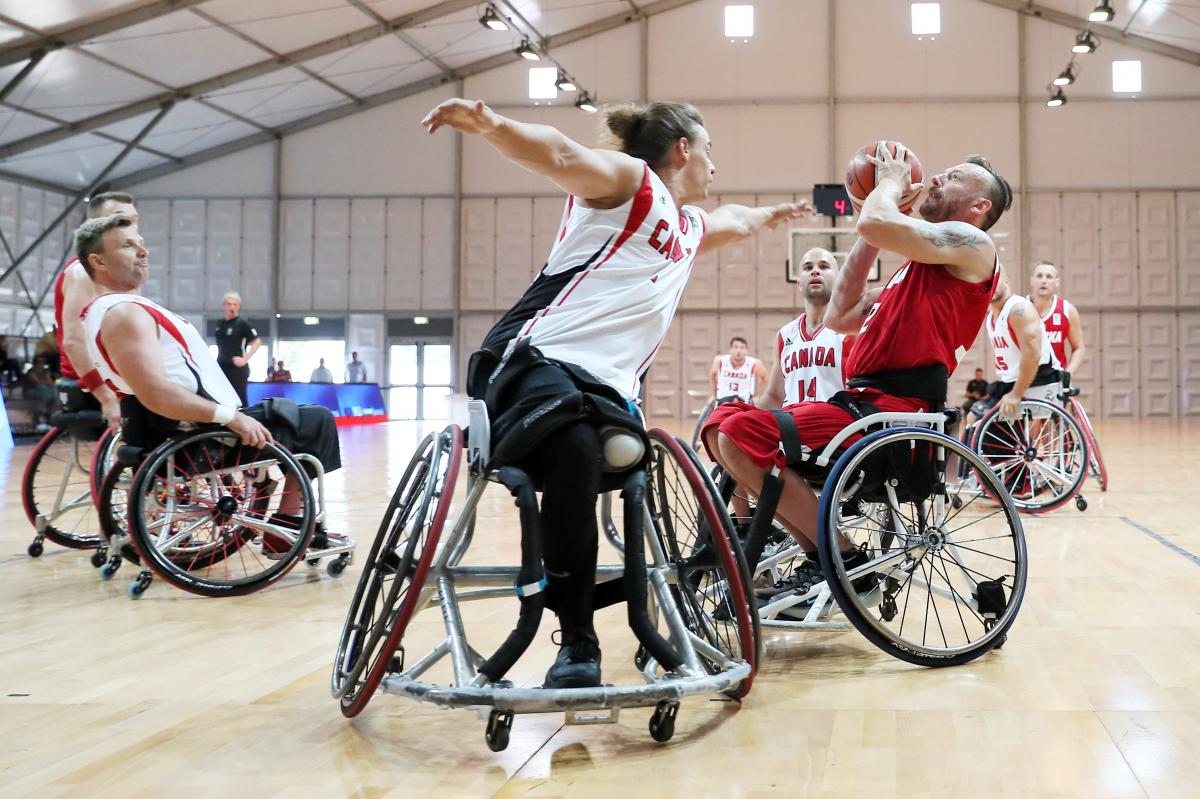 Polish and Canadian male wheelchair basketballers fighting it out on the court