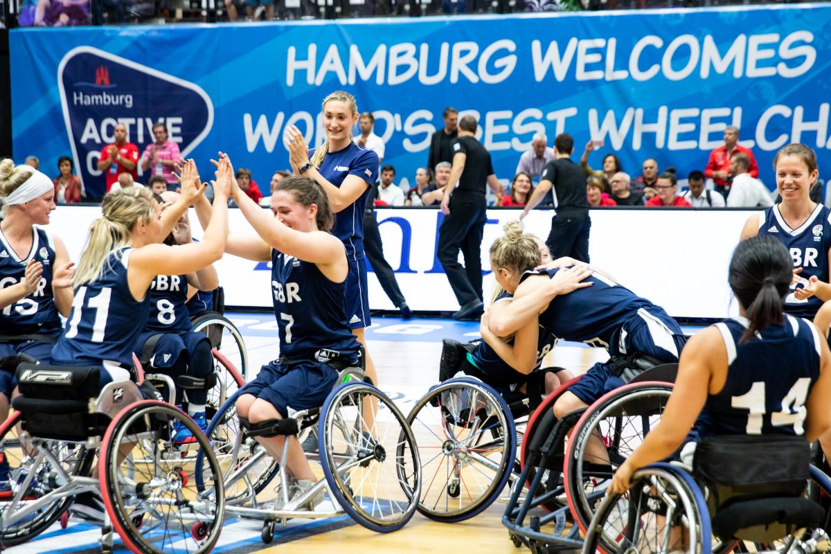 Great Britain beat Germany - Hamburg 2018 a group of female British wheelchair basketballers hugging and smiling on court