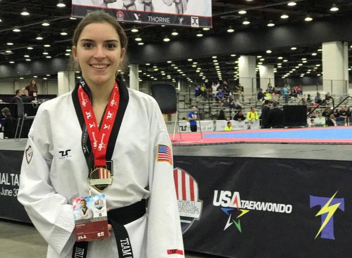 US woman taekwondo fighter poses with medal around her neck