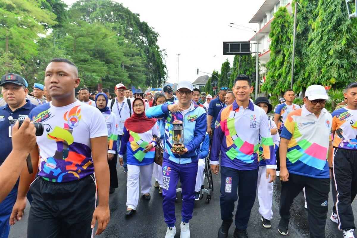 People marching together for a torch relay lighting ceremony