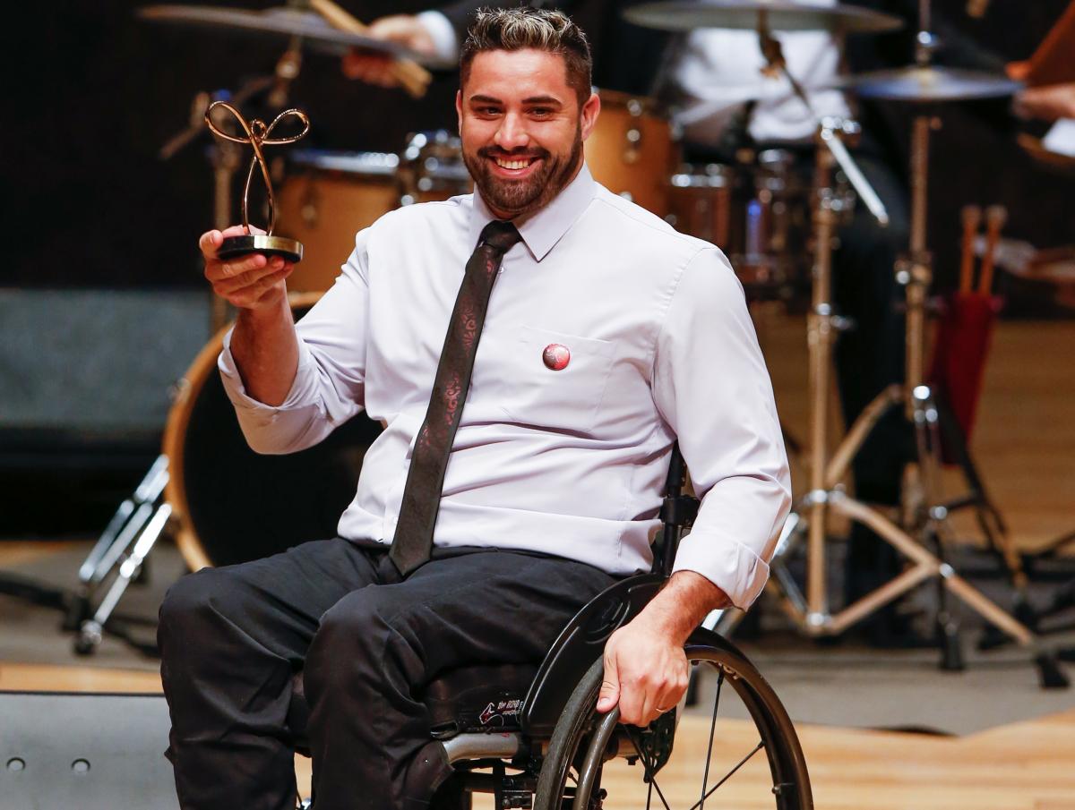 Jovane Guissone male wheelchair fencer Jovane Guissone holds up a trophy
