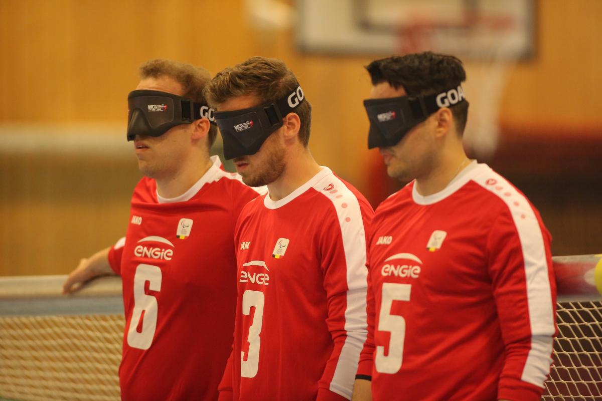 three Belgian male goalball players lined up in a row