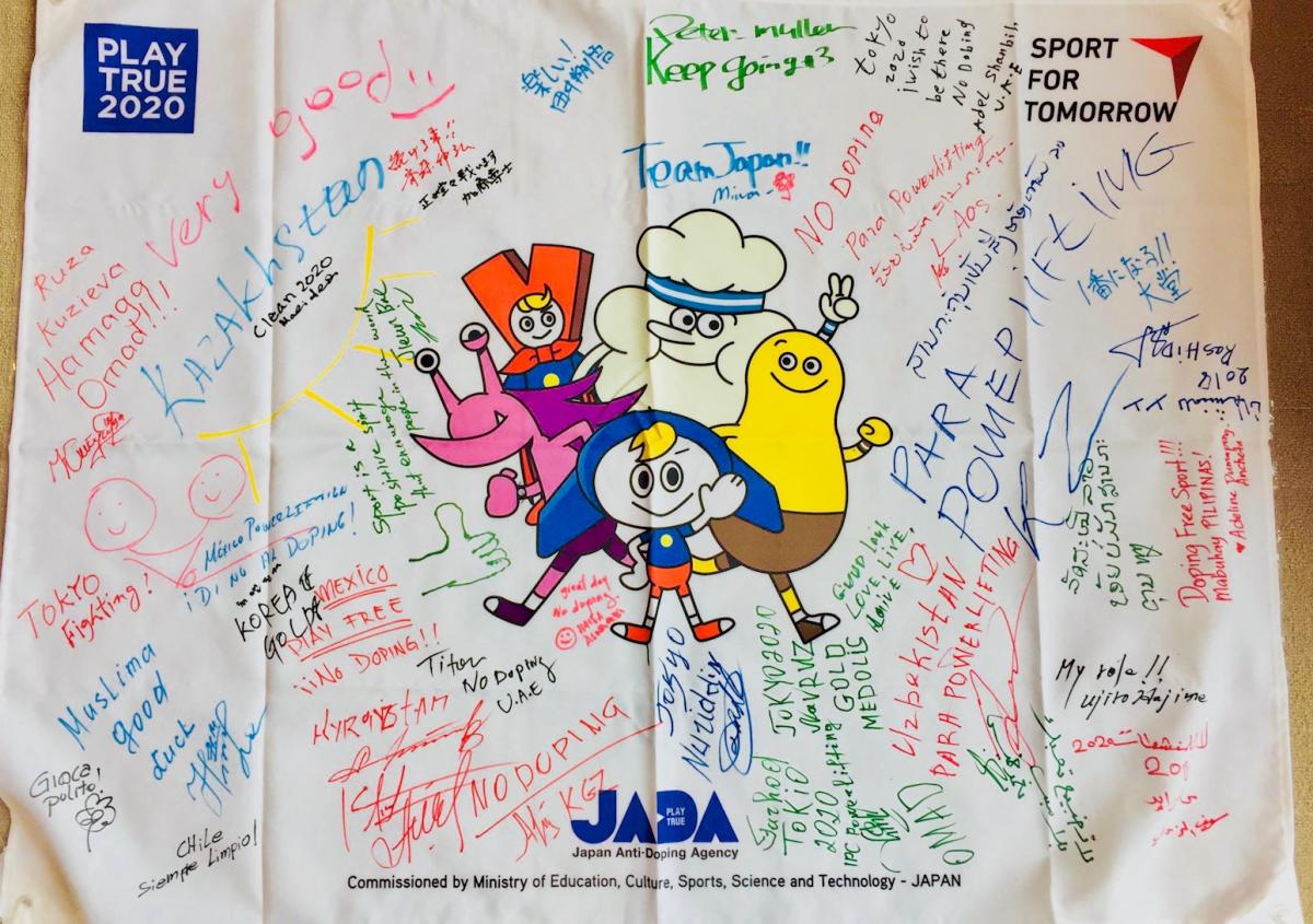 a flag from the Raise the Bar anti-doping programme covered with signatures 