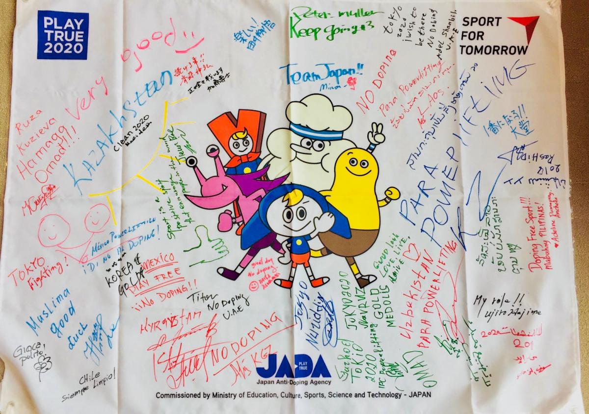Raise the Bar commitment message a flag from the Raise the Bar anti-doping programme covered with signatures