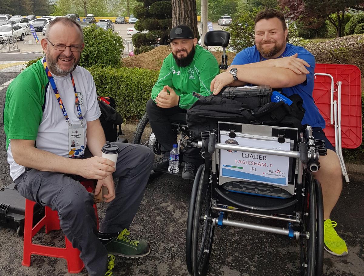 male Para shooter Phil Eaglesham with his coach and assistant outside