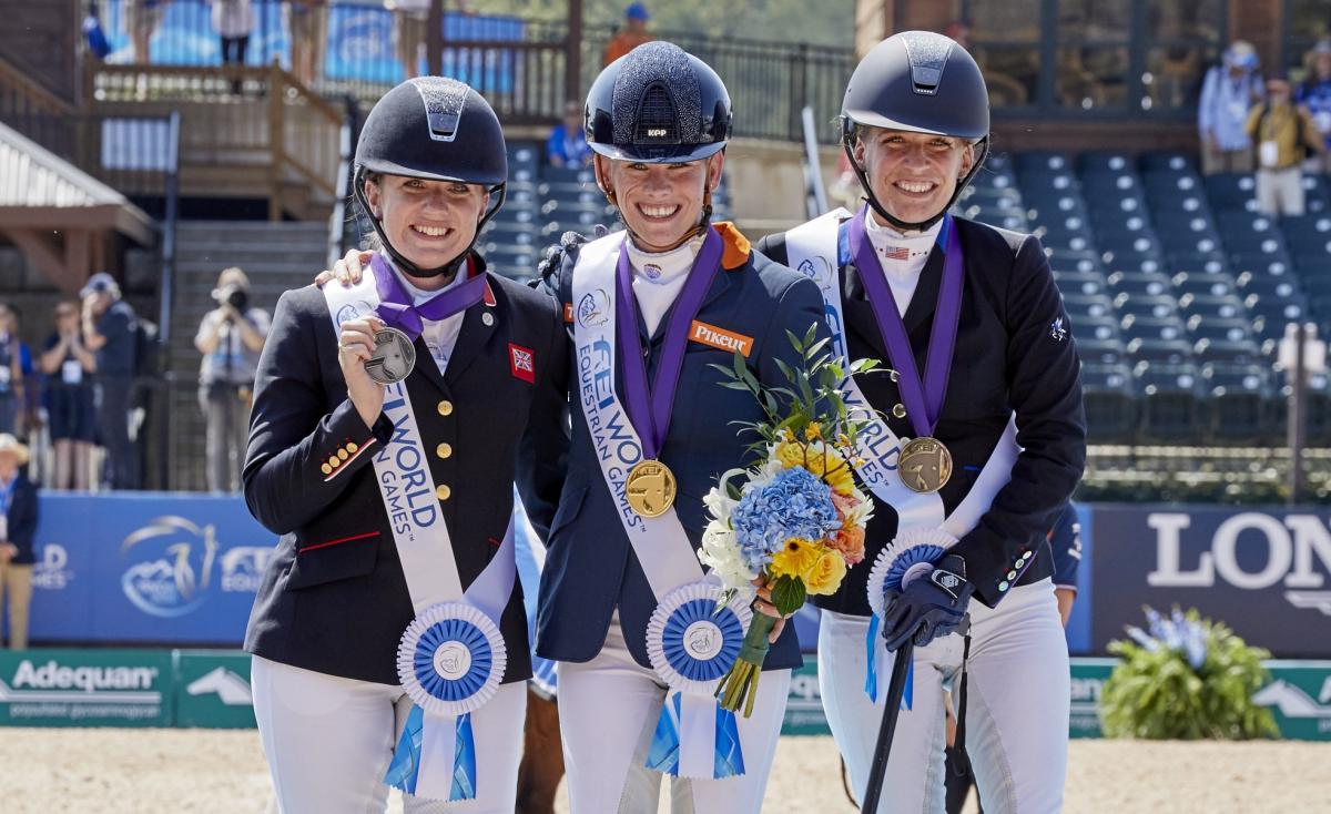 three female Para equestrian riders with Rixt van der Horst in the centre, standing on the podium