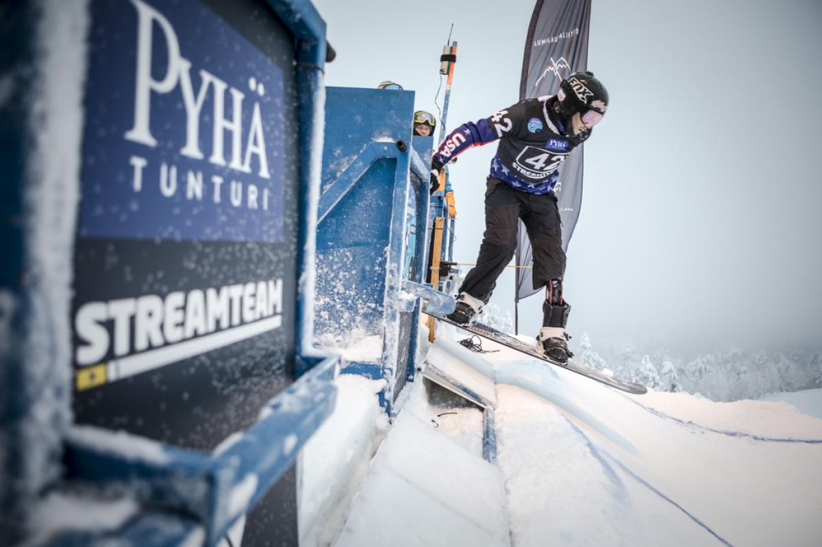 a Para snowboarder rides out of the start gate