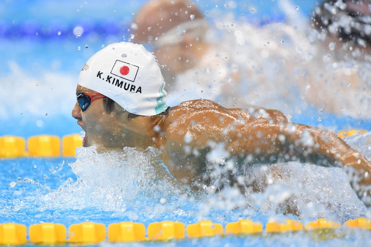 Man swimming with a cap showing the Japanese flag