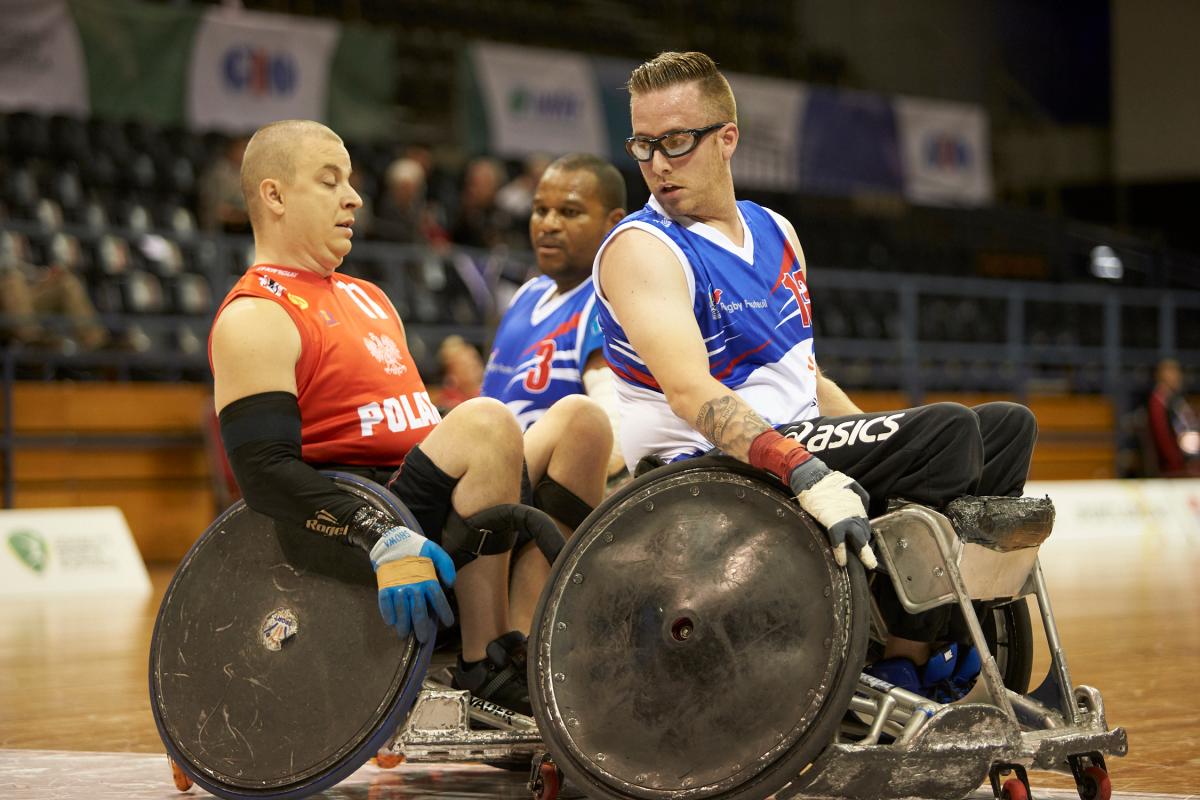French and Polish wheelchair rugby players in action on the court