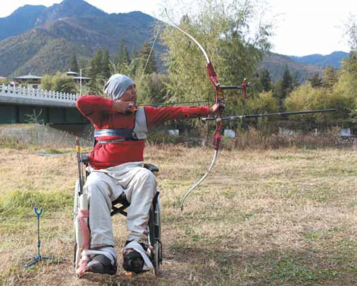 male Para archer Pema Rigsel prepares to shoot an arrow