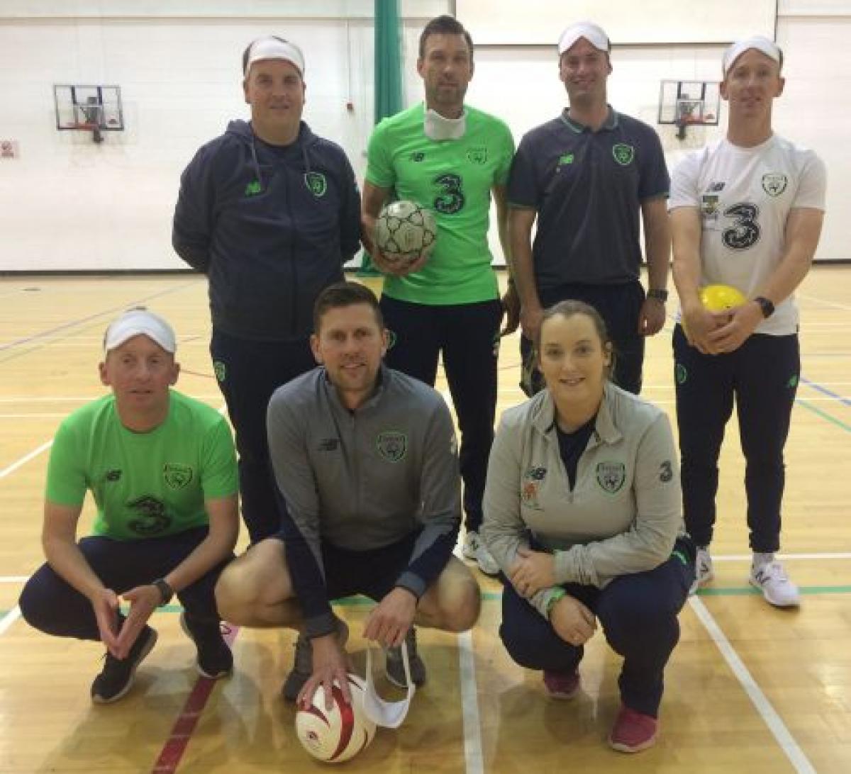 a group of blind footballers in an Ireland gym holding footballs