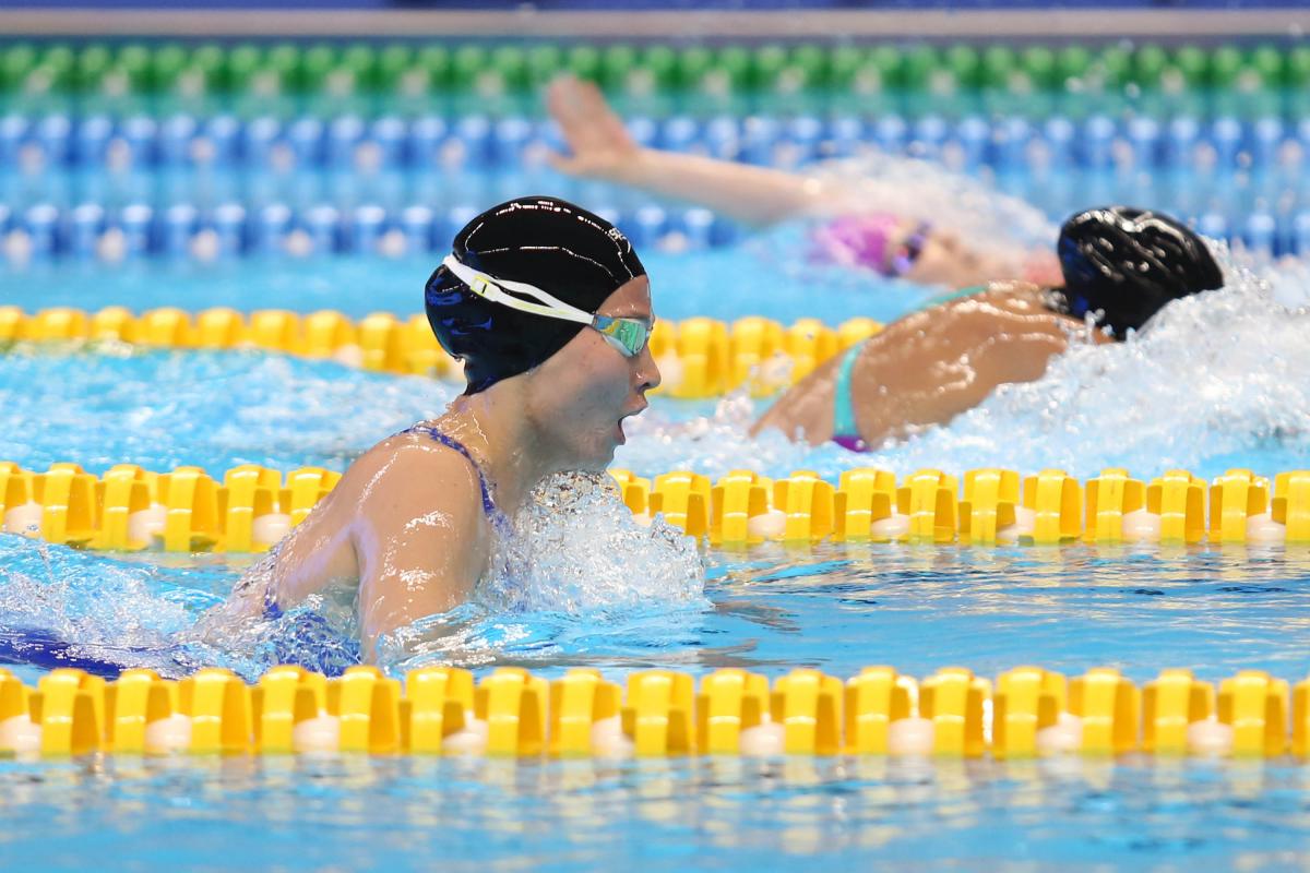female Para swimmer Amilova Fotimakhon takes a breath during a breaststroke