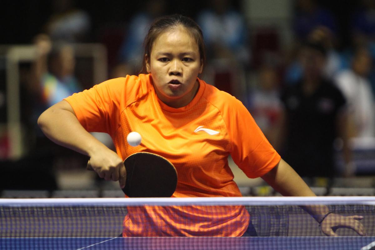 Indonesia Suwarti Suwarti - Para table tennis - Asian Para Games Woman in orange shirt playing table tennis