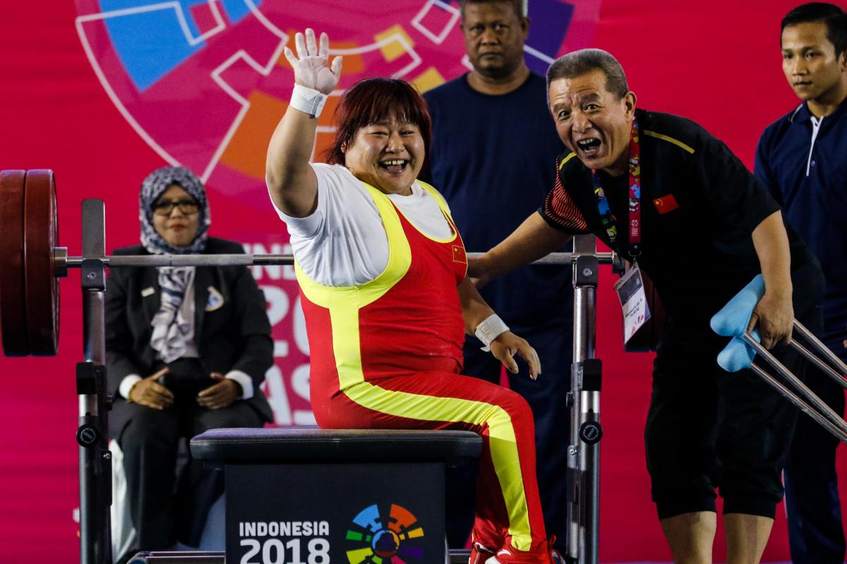 Xu Lili - Indonesia 2018 female powerlifter Xu Lili waves and smiles while sitting on the bench