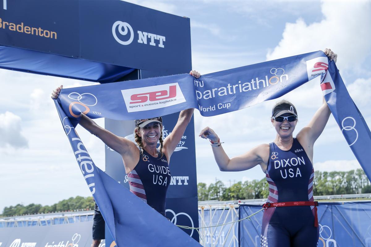 female Para triathlete Amy Dixon and her guide cross the finish line