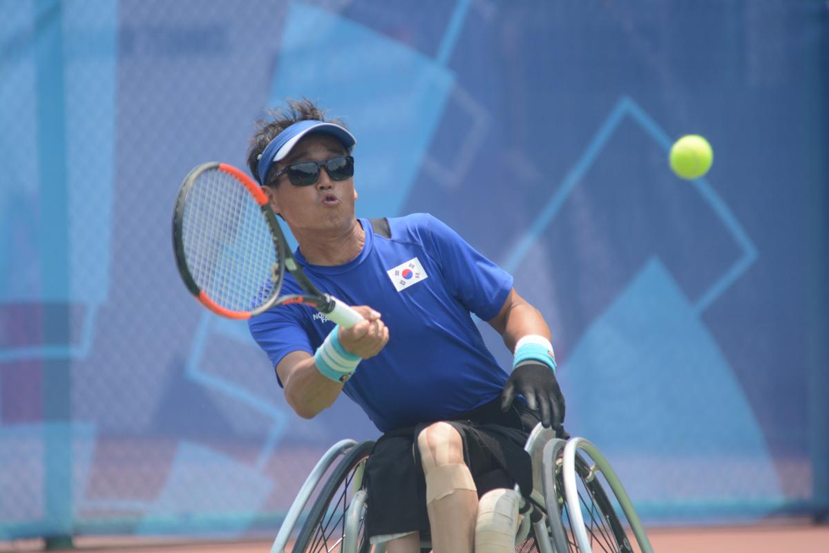 male wheelchair tennis player Kyu-Seung Kim plays a forehand