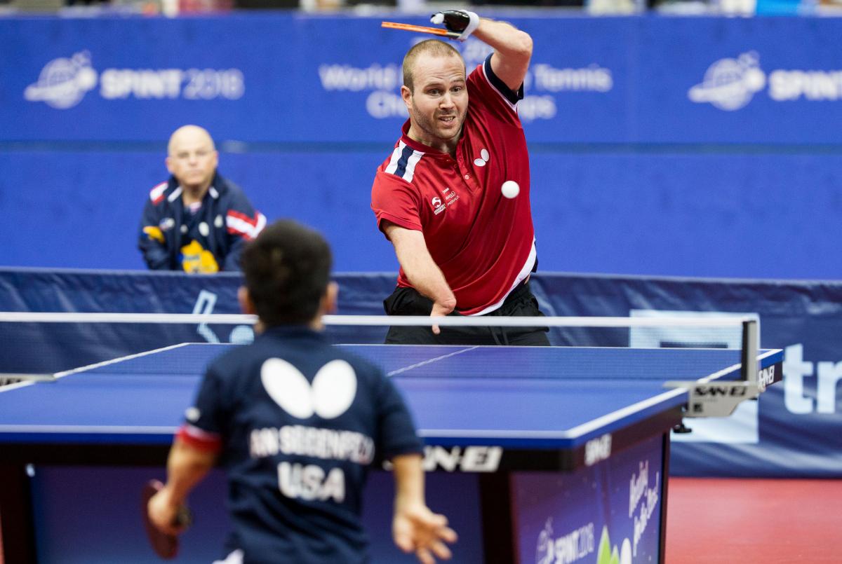 male Para table tennis player Peter Rosenmeier plays a forehand