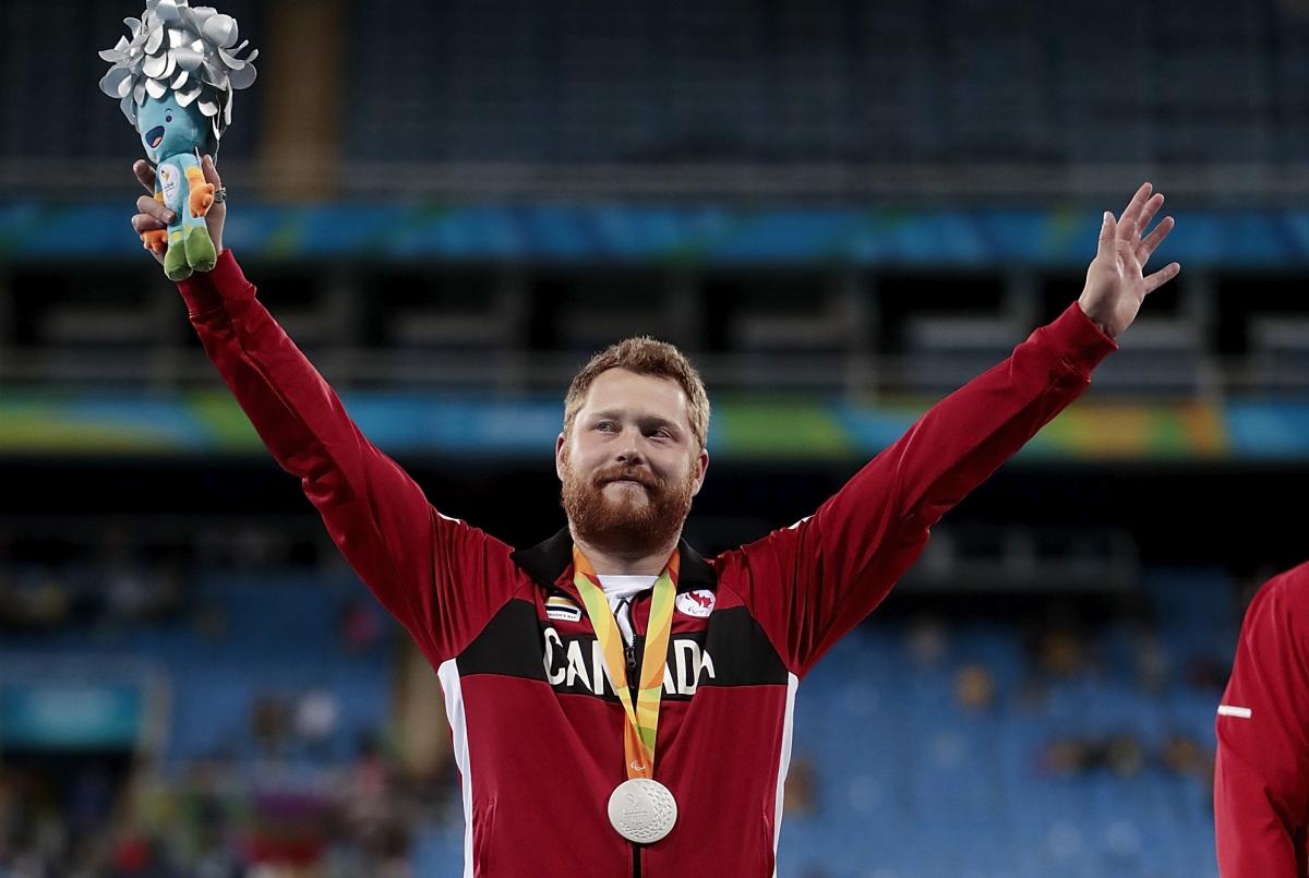 Alister McQueen - Rio 2016 male Para athlete Alister McQueen raises his arms on the podium