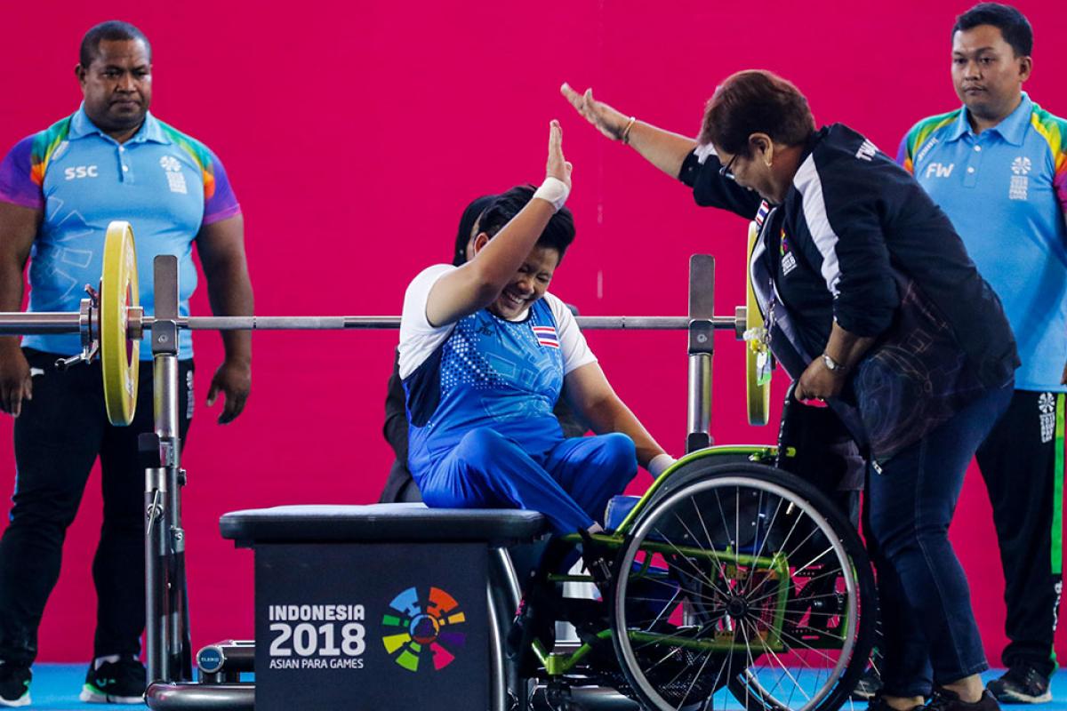 Para powerlifting - Indonesia 2018 Asian Para Games Woman powerlifter on a bench celebrating with another woman