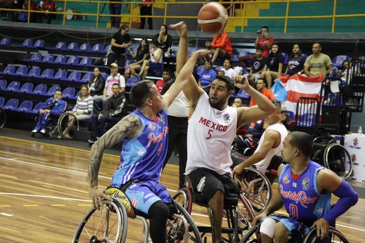 male wheelchair basketballers from Mexico and Puerto Rico fight for the ball