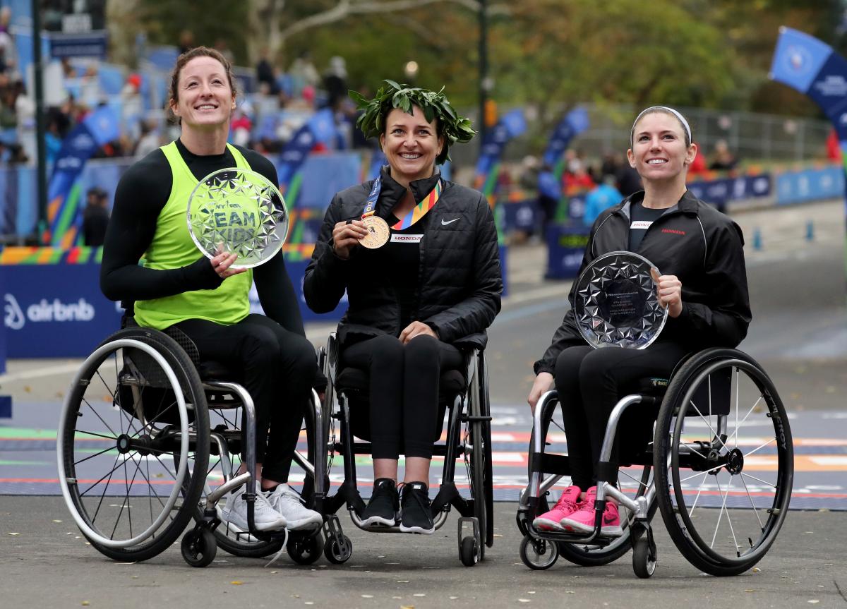 female wheelchair racers Tatyana McFadden, Manuela Schaer and Amanda McGrory holding up trophies