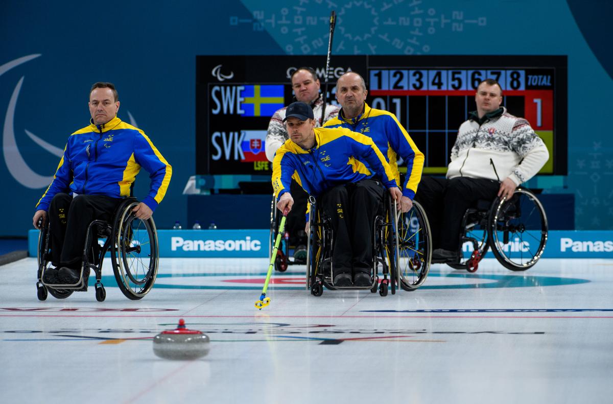 male wheelchair curler Viljo Petersson Dahl plays a stone on the ice
