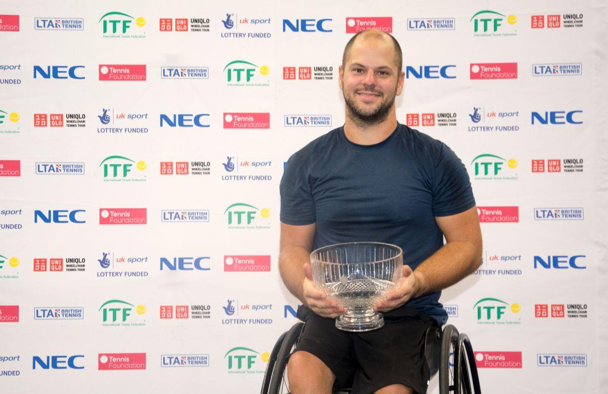 male wheelchair tennis player Stefan Olsson smiling and holding a crystal trophy