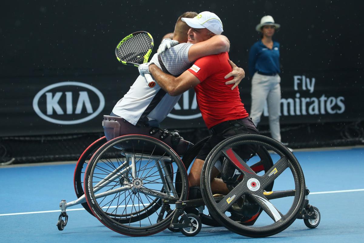 male wheelchair tennis players Stephane Houdet and Nicolas Peifer hugging on the court