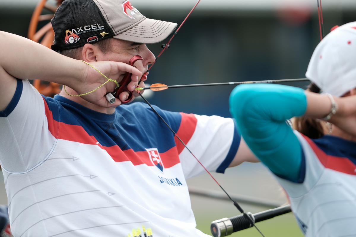 male Para archer Marcel Pavlik pulls back an arrow ready to shoot