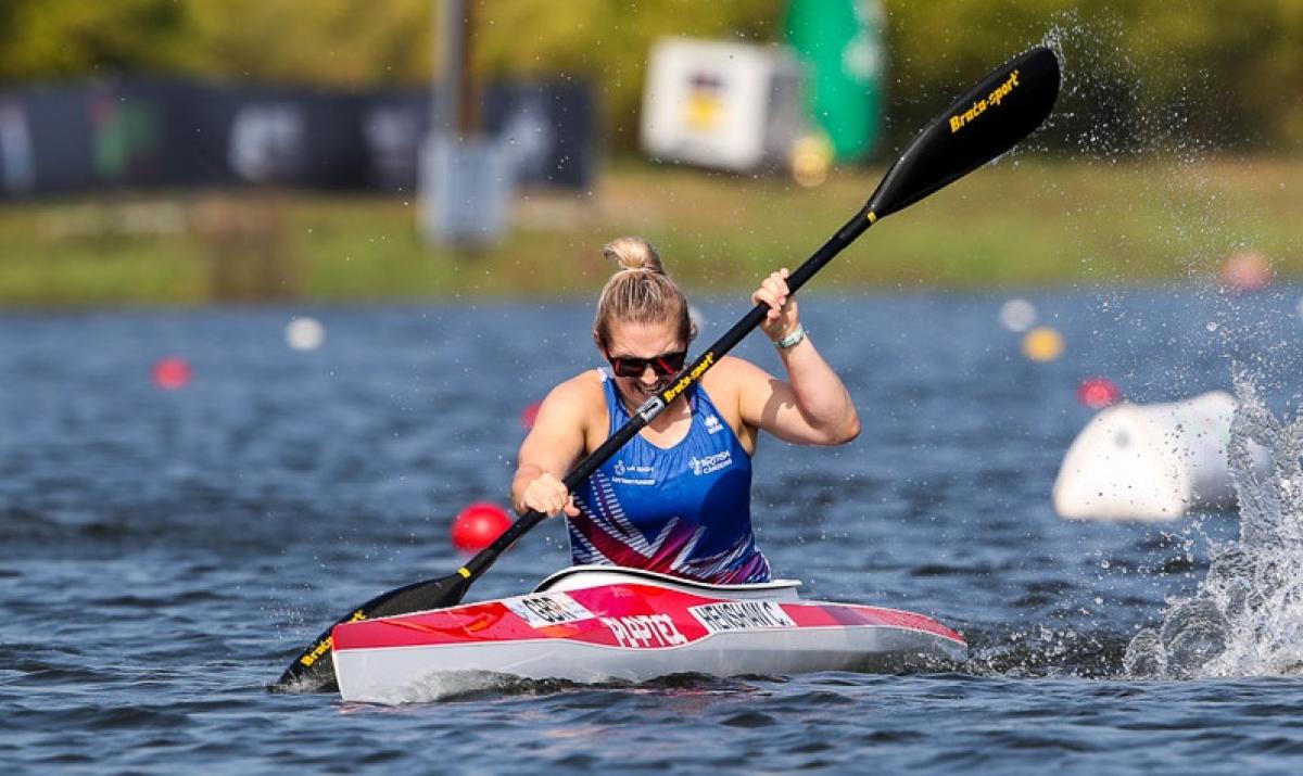 female Para canoeist Charlotte Henshaw makes a stroke through the water