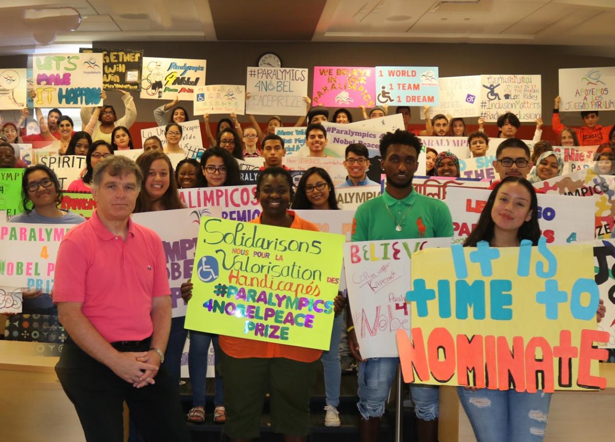 a group of students in a classroom holding up different coloured banners