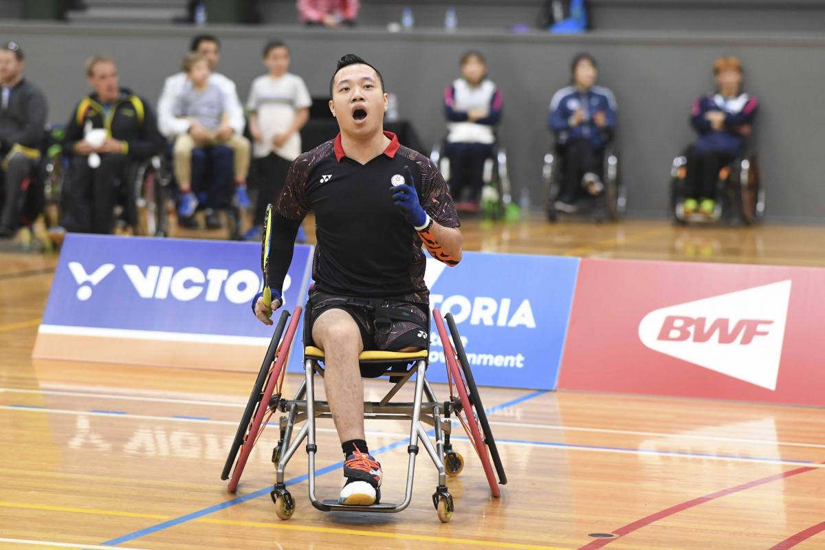 male Para badminton player Chan Ho Yuen punches the air after a winning shot