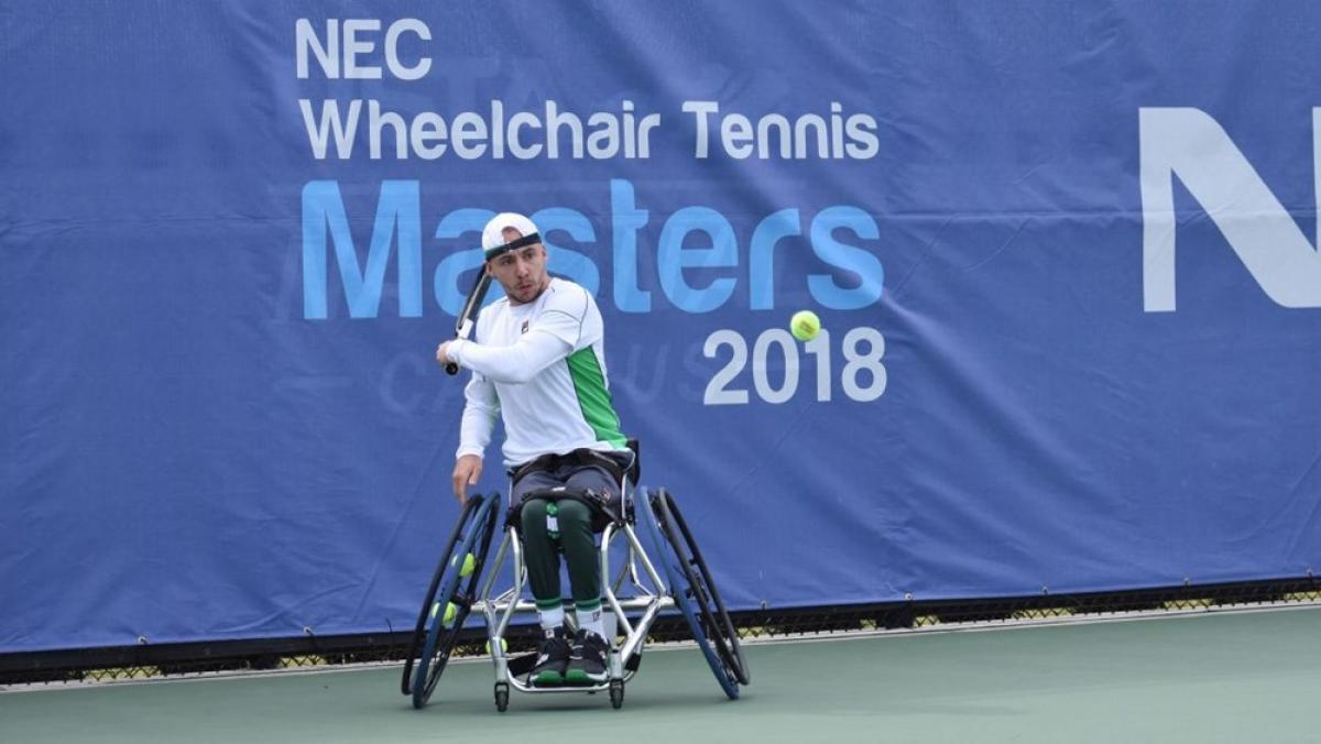 Male in wheelchair hits a tennis ball