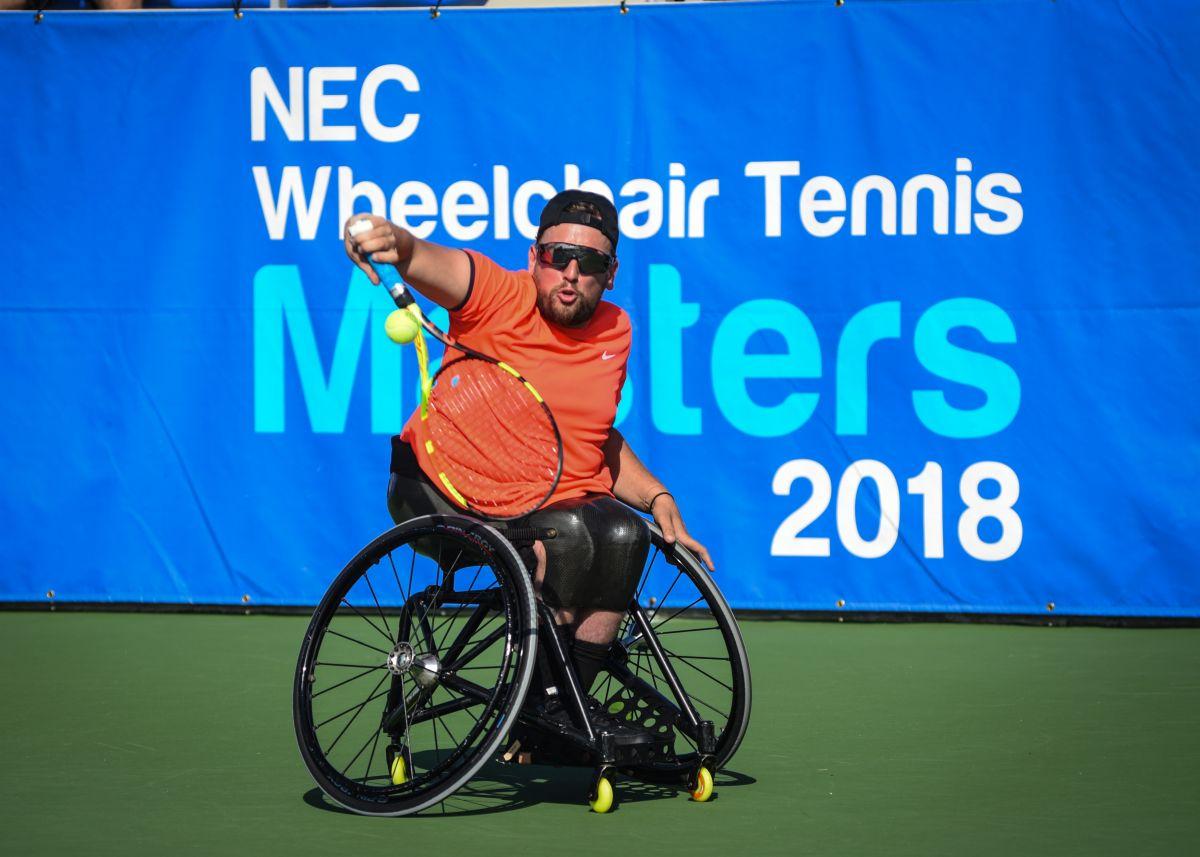 male wheelchair tennis player Dylan Alcott plays a backhand on a hard court