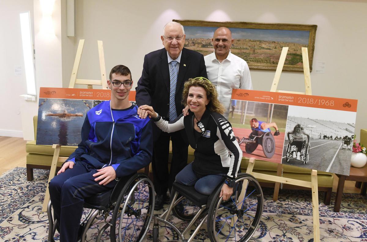 two people in wheelchairs seated next to two people standing