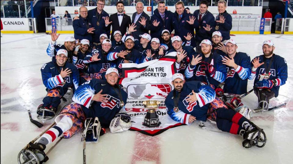 A group of Para ice hockey players celebrating on ice