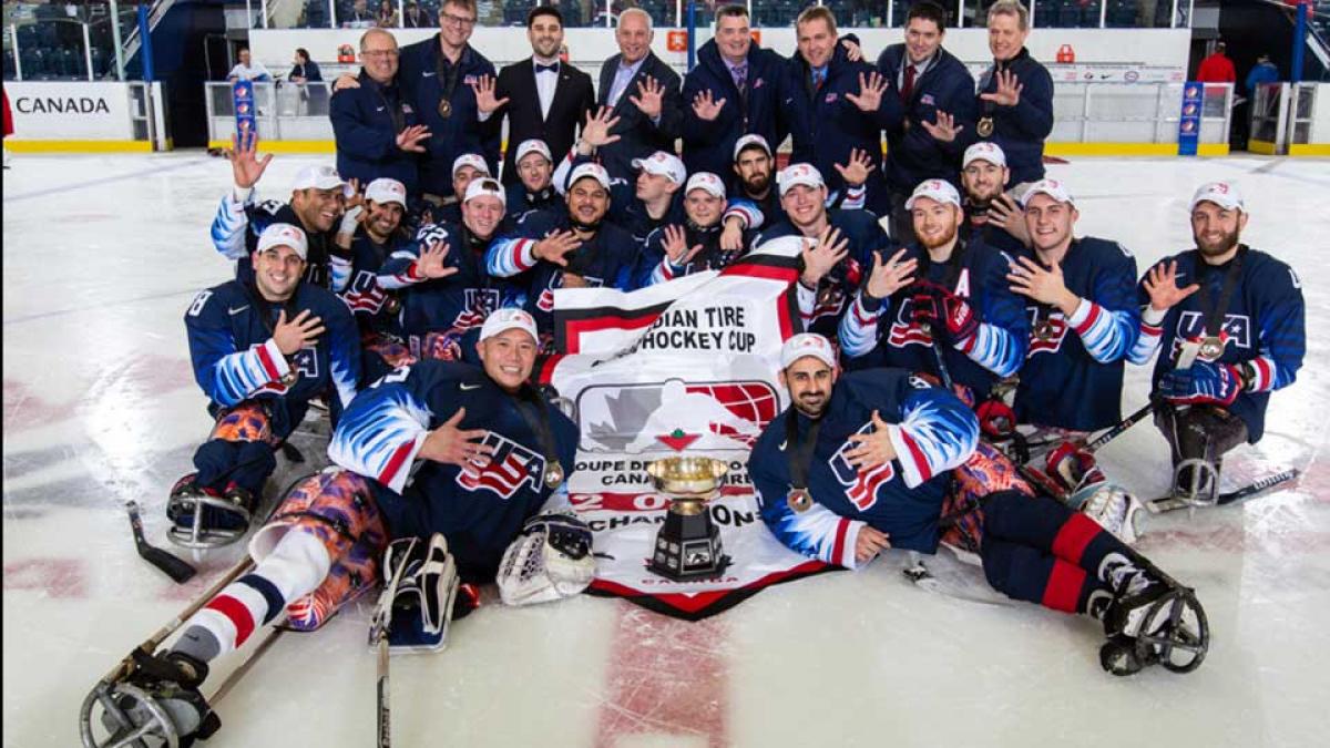 A group of Para ice hockey players celebrating on ice