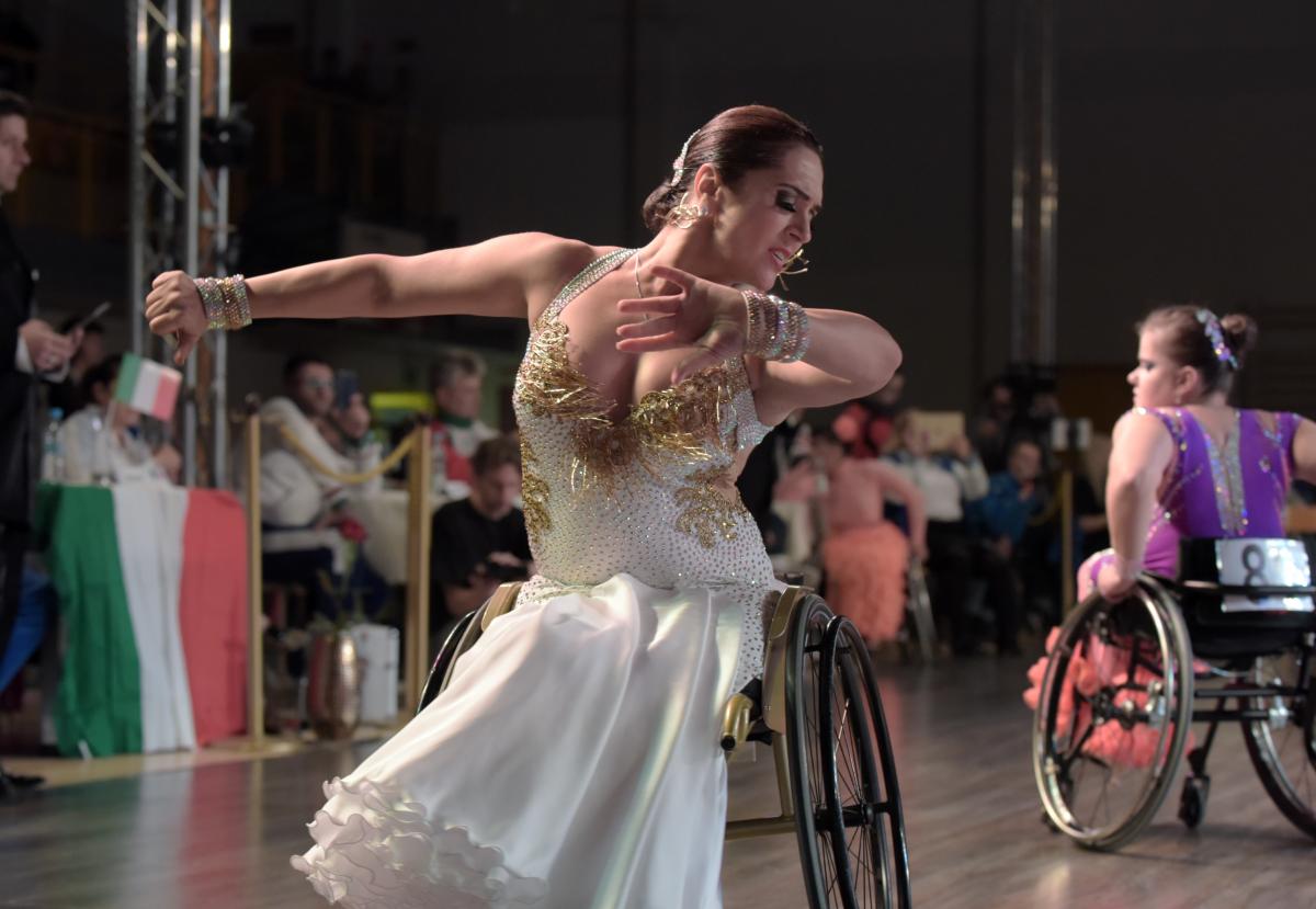 Ukrainian dancer in wheelchair wears glittering dress dances a conventional style