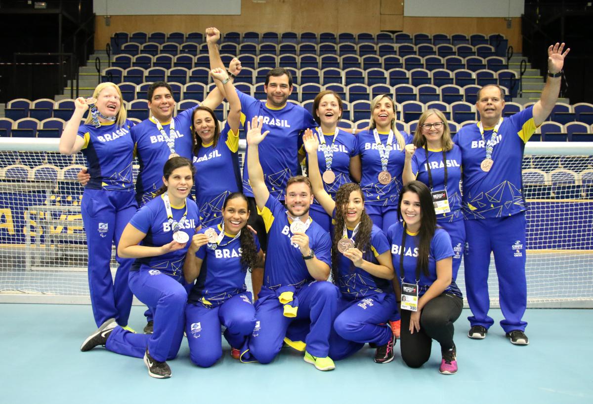 a group of female Brazilian goalballers smiling with medals round their necks