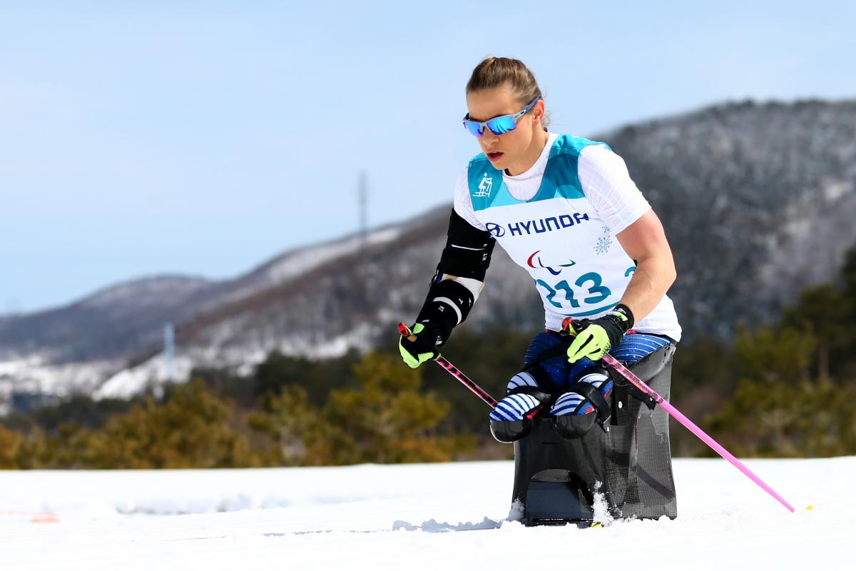 Oksana Masters - cross-country skiing female sit skier Oksana Masters pushing through the snow
