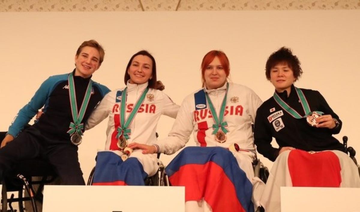 female wheelchair fencers Ludmila Vasileva and Beatrice Vio hugging on the podium