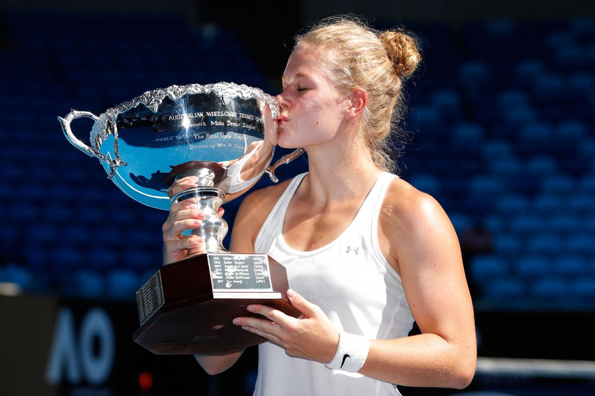 female wheelchair tennis player Diede de Groot holds up a trophy and kisses it
