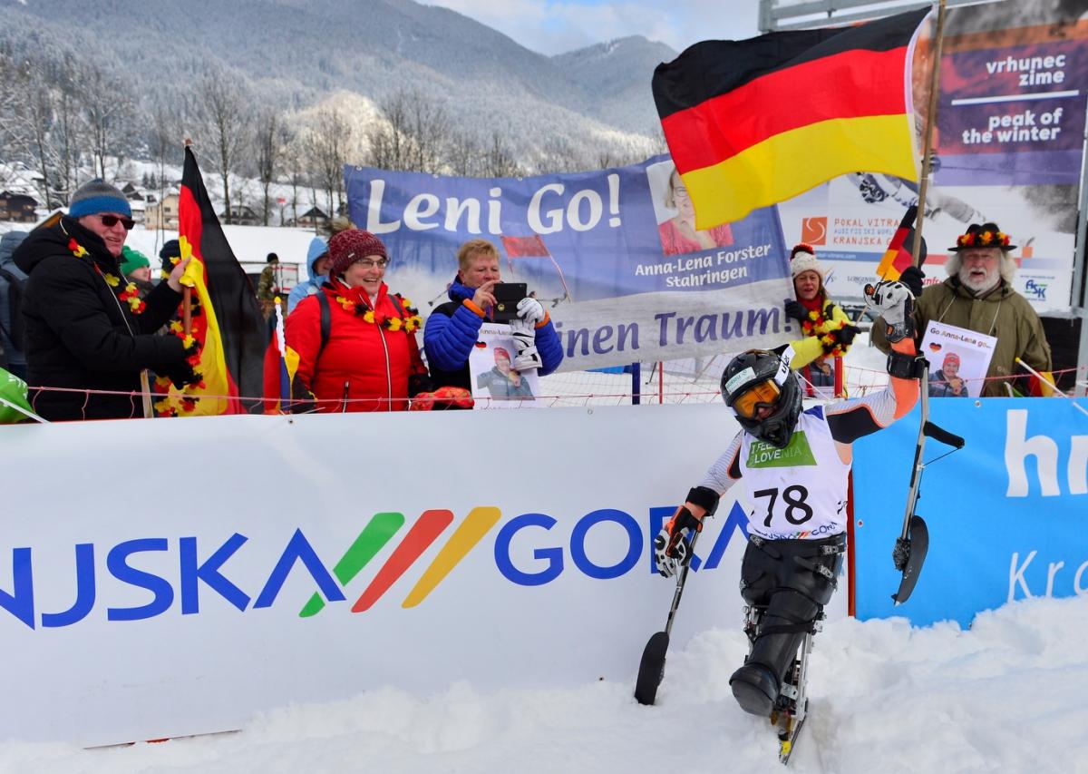 A sit-skier celebreating in front of a group of five people