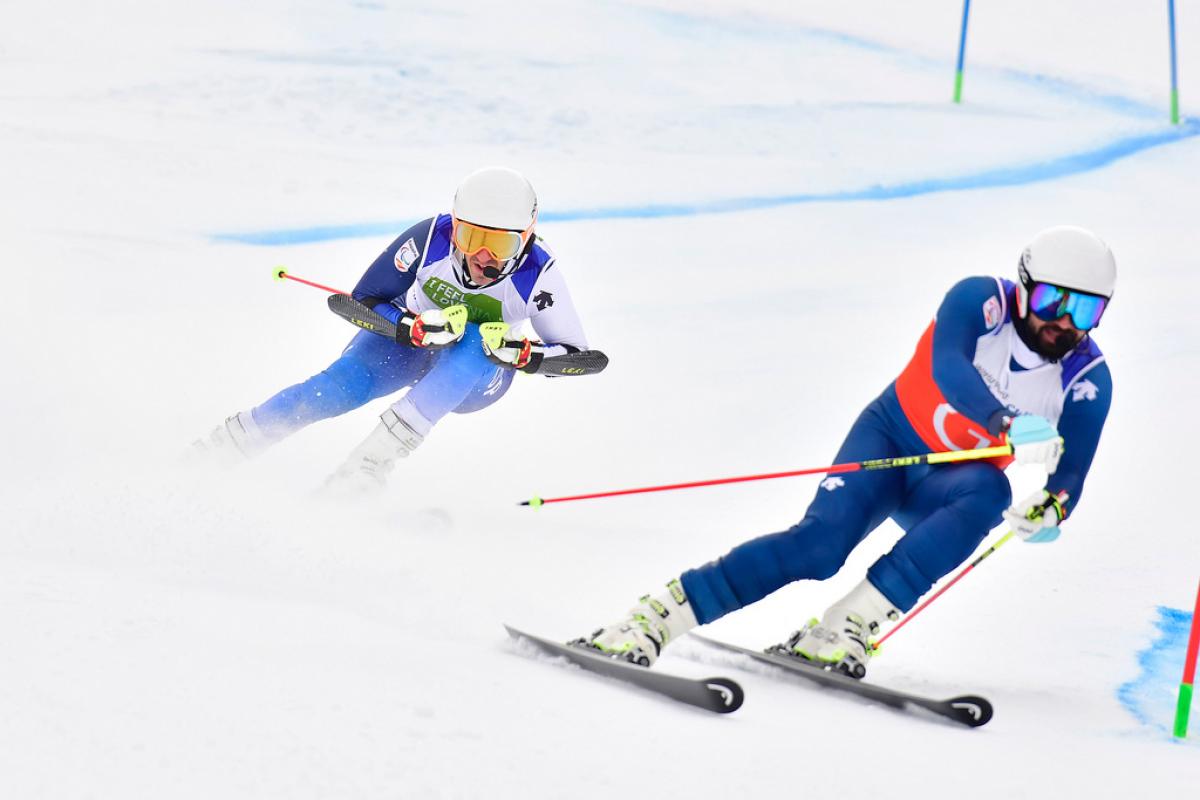 male vision impaired Para alpine skier Jon Santacana Maiztegui skies through a gate following his guide skier