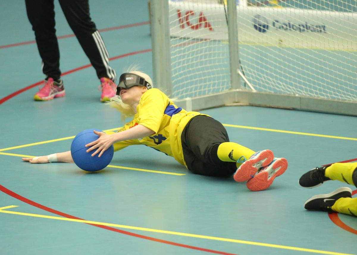 a female goalball player makes a save on the ground