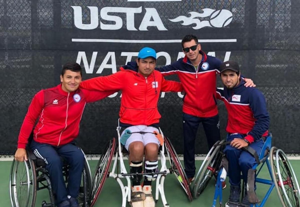 Chile wheelchair tennis team - World Team Cup three male wheelchair tennis players and another man with their arms around eachother on a hard court
